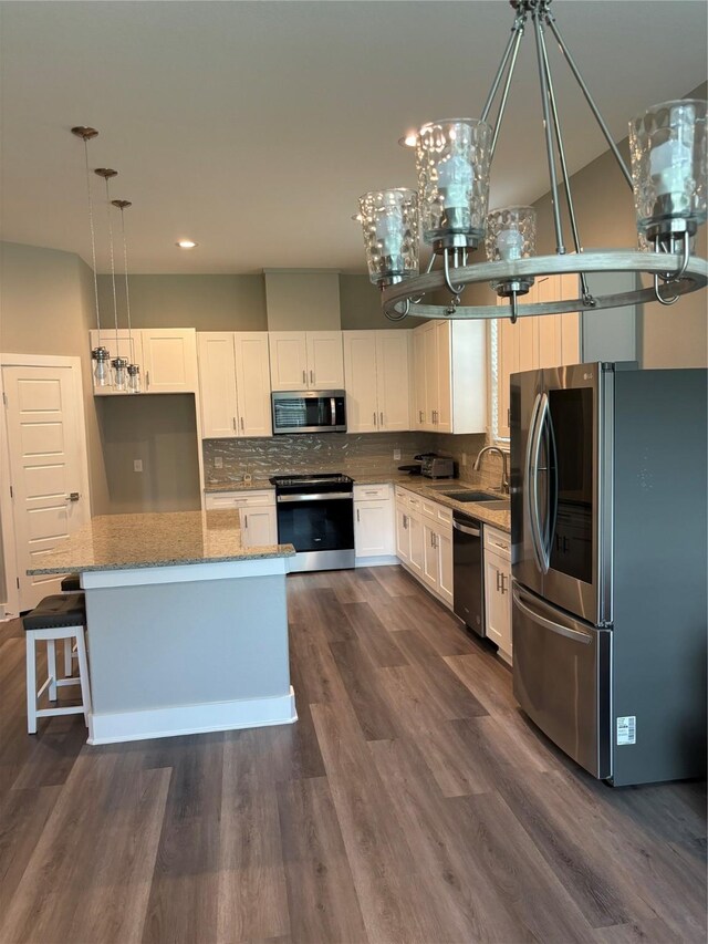 170 Nuuanu Ln, Bastrop, TX 78602 - kitchen with appliances with stainless steel finishes, a sink, light stone countertops, white cabinetry, and decorative backsplash