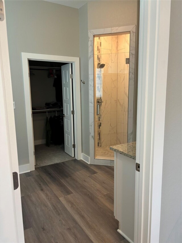 170 Nuuanu Ln, Bastrop, TX 78602 - bathroom with a stall shower, wood finished floors, a spacious closet, and baseboards