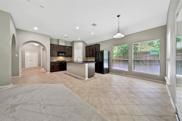 27506 Colin Springs Ln, Spring, TX 77386 - kitchen featuring black appliances, open floor plan, a sink, arched walkways, and decorative backsplash