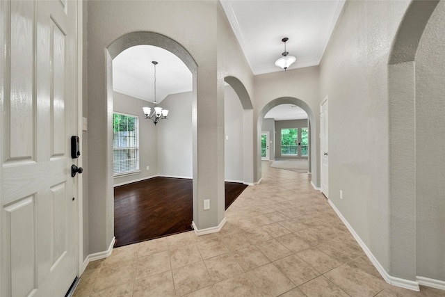 27506 Colin Springs Ln, Spring, TX 77386 - tiled entryway with arched walkways, healthy amount of natural light, crown molding, a textured wall, and a chandelier