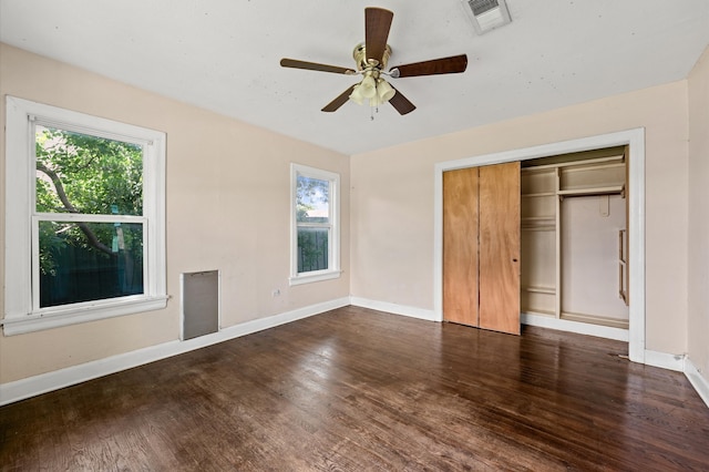 1922 Des Jardines St, Houston, TX 77023 - unfurnished bedroom with multiple windows, dark wood-style floors, baseboards, and a closet
