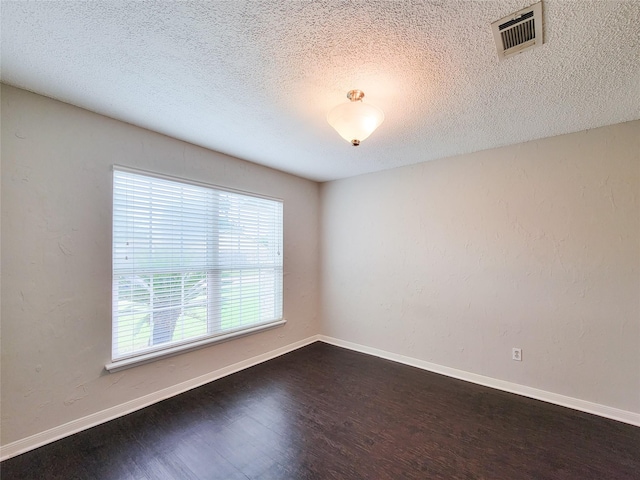 6722 Loch Bruceray Dr, Houston, TX 77084 - empty room featuring dark wood-style flooring, a textured ceiling, and baseboards