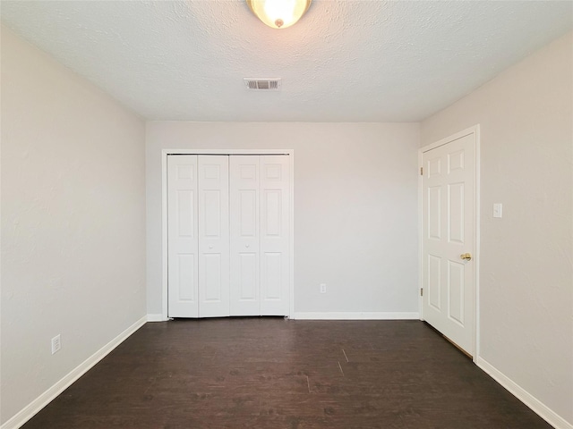 6722 Loch Bruceray Dr, Houston, TX 77084 - unfurnished bedroom featuring baseboards, a closet, dark wood-style floors, and a textured ceiling