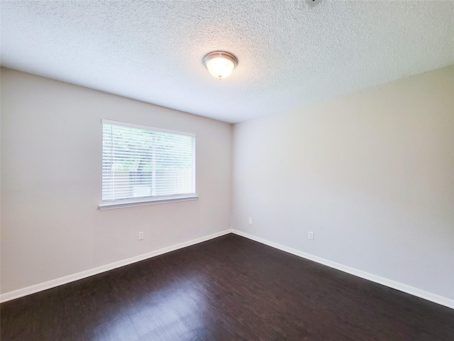 6722 Loch Bruceray Dr, Houston, TX 77084 - empty room with dark wood finished floors, baseboards, and a textured ceiling