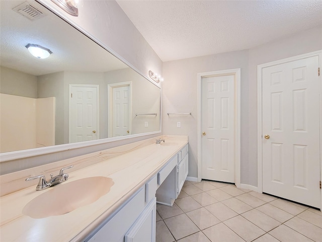 6722 Loch Bruceray Dr, Houston, TX 77084 - full bathroom featuring a textured ceiling, tile patterned flooring, double vanity, and baseboards