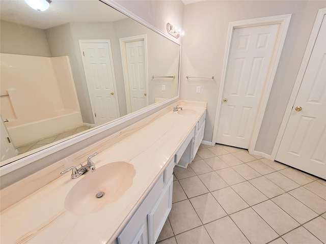 6722 Loch Bruceray Dr, Houston, TX 77084 - bathroom featuring tile patterned flooring, double vanity, a tub to relax in, and baseboards