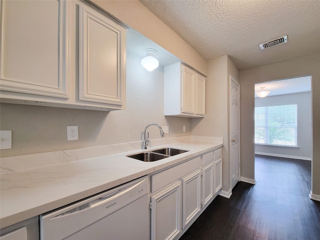 6722 Loch Bruceray Dr, Houston, TX 77084 - kitchen with white dishwasher, a sink, dark wood-type flooring, white cabinets, and baseboards