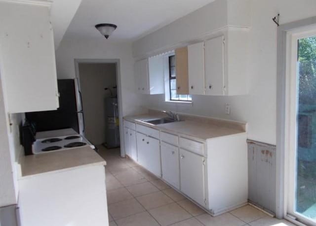 111 Sowescor St, Crockett, TX 75835 - kitchen with water heater, electric stove, a sink, light countertops, and light tile patterned floors