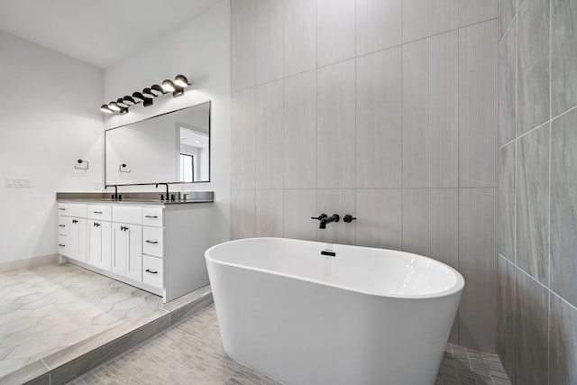 1706 Sedola Ln, Houston, TX 77055 - bathroom featuring a freestanding bath, double vanity, and tile walls