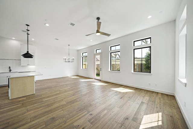 1706 Sedola Ln, Houston, TX 77055 - unfurnished living room featuring a ceiling fan, a chandelier, light wood-style flooring, recessed lighting, and baseboards