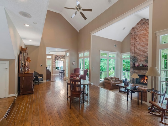 23222 Red Oak Trl, Tomball, TX 77377 - dining room with hardwood / wood-style floors, a ceiling fan, high vaulted ceiling, healthy amount of natural light, and a brick fireplace
