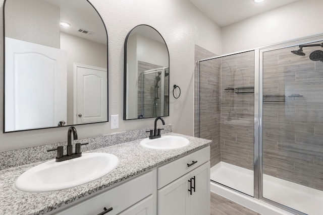 24719 Colony Meadow Trl, Huffman, TX 77336 - full bathroom with a shower stall, double vanity, and wood finished floors