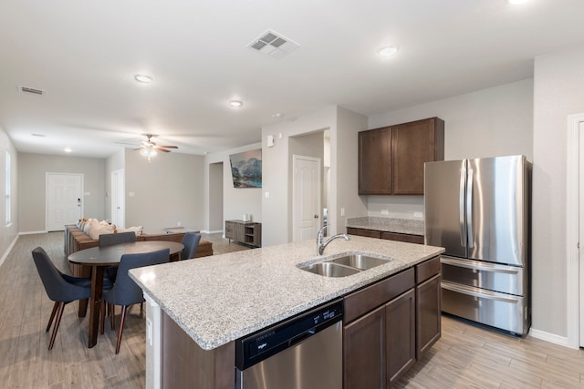 24719 Colony Meadow Trl, Huffman, TX 77336 - kitchen featuring appliances with stainless steel finishes, a sink, dark brown cabinetry, baseboards, and recessed lighting