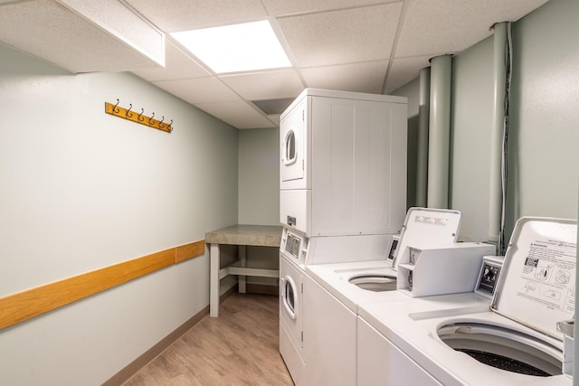 6102 Seawall Blvd Unit 140, Galveston, TX 77551 - shared laundry room featuring stacked washing machine and dryer, light wood finished floors, washer and clothes dryer, and baseboards