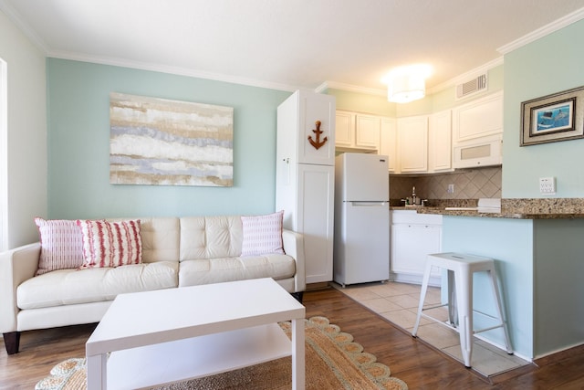 6102 Seawall Blvd Unit 140, Galveston, TX 77551 - living room with light wood finished floors and ornamental molding