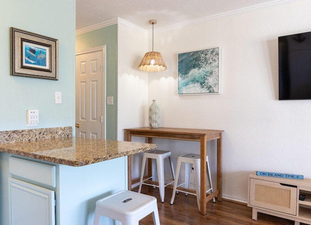 6102 Seawall Blvd Unit 140, Galveston, TX 77551 - kitchen with crown molding, dark wood-type flooring, light stone countertops, and decorative light fixtures