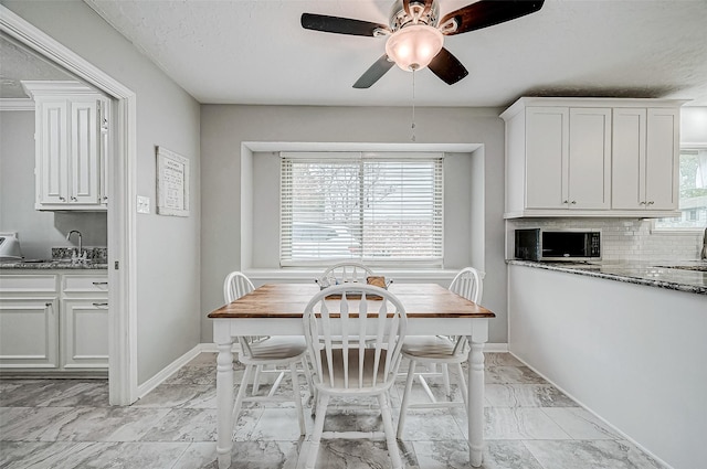 11607 Knobcrest Dr, Houston, TX 77070 - dining room with light marble finish floors, a ceiling fan, and baseboards