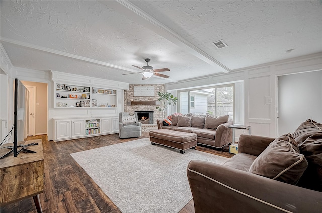 11607 Knobcrest Dr, Houston, TX 77070 - living area featuring a textured ceiling, ceiling fan, dark wood-style floors, a brick fireplace, and a decorative wall