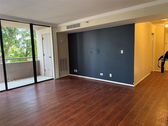 spare room featuring crown molding, wood finished floors, and baseboards