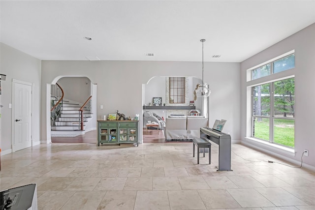 dining room with healthy amount of natural light, arched walkways, stairway, and baseboards