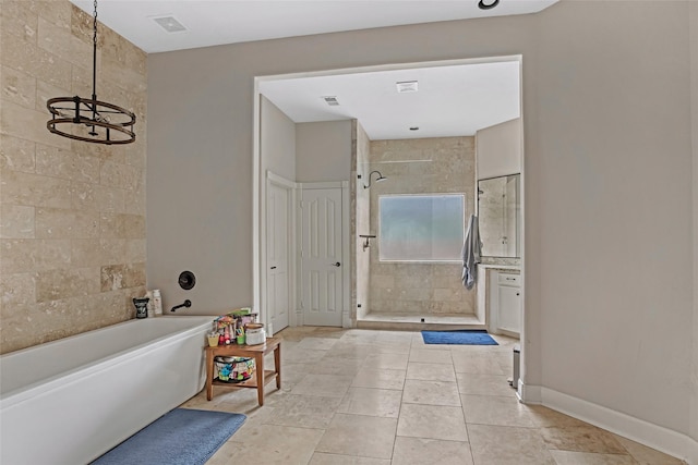 full bath featuring a shower stall, a freestanding bath, a chandelier, baseboards, and tile patterned flooring