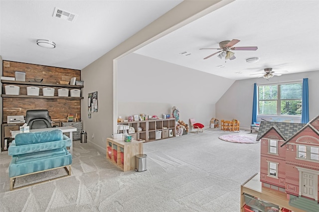 playroom with a wood stove, a ceiling fan, lofted ceiling, carpet, and baseboards
