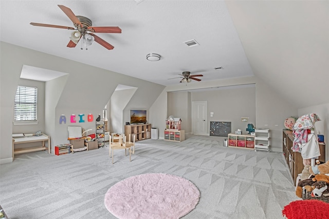 game room with a ceiling fan, vaulted ceiling, and carpet