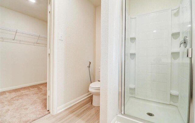 2037 Mule Rdg, Katy, TX 77493 - full bath featuring toilet, a stall shower, wood finished floors, a spacious closet, and baseboards