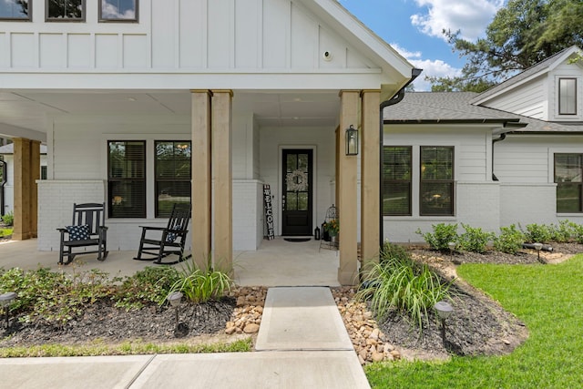 19720 Holly Creek Bnd, Magnolia, TX 77355 - view of exterior entry with a porch, brick siding, board and batten siding, and roof with shingles