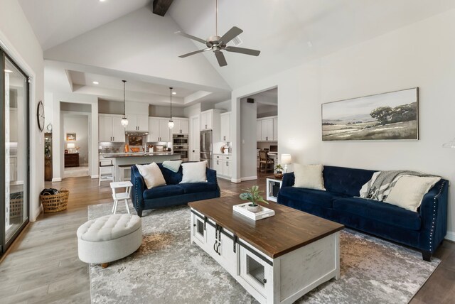 19720 Holly Creek Bnd, Magnolia, TX 77355 - living room featuring light wood finished floors, a ceiling fan, high vaulted ceiling, beam ceiling, and recessed lighting