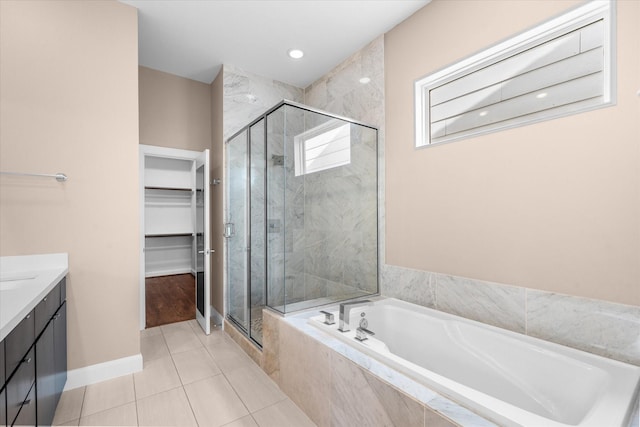 3115 Leeland St, Houston, TX 77003 - full bathroom with a walk in closet, a shower stall, vanity, a garden tub, and baseboards