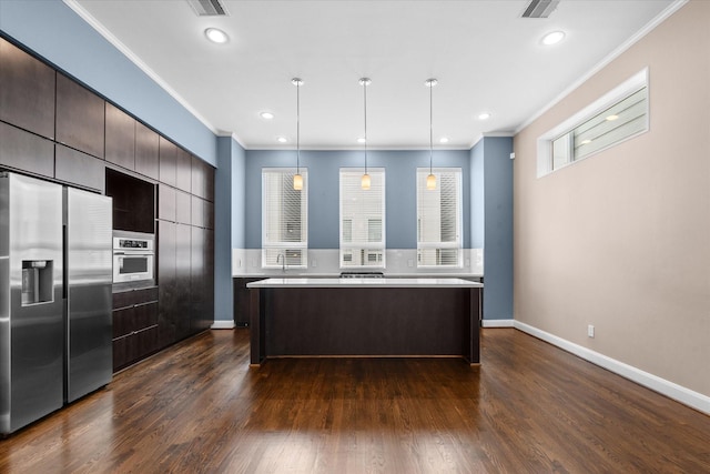 3115 Leeland St, Houston, TX 77003 - kitchen with appliances with stainless steel finishes, crown molding, light countertops, a kitchen island, and dark wood-type flooring