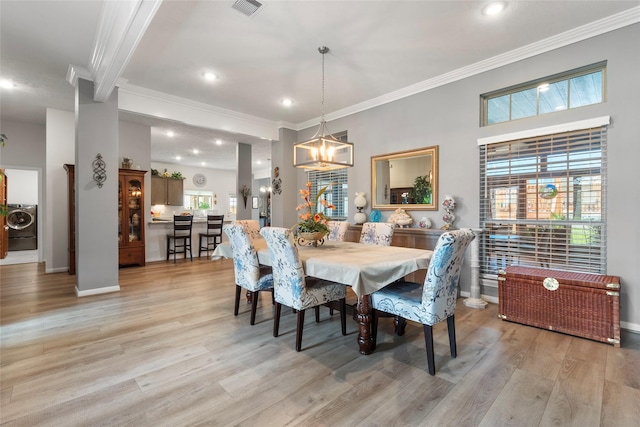 3314 Bastian Rd, Dickinson, TX 77539 - dining room featuring washer / dryer, crown molding, light wood-style flooring, a chandelier, and baseboards