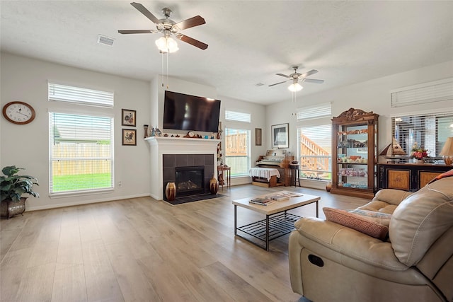 3314 Bastian Rd, Dickinson, TX 77539 - living room featuring a ceiling fan, light wood-type flooring, a fireplace, and baseboards