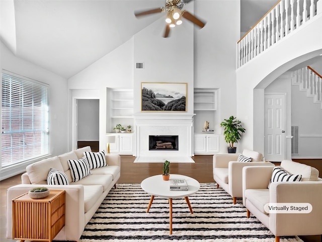 22014 Mission Hills Ln, Katy, TX 77450 - living area with high vaulted ceiling, arched walkways, a ceiling fan, built in shelves, and wood finished floors