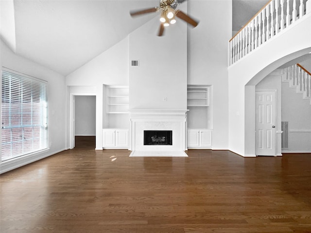 22014 Mission Hills Ln, Katy, TX 77450 - unfurnished living room with high vaulted ceiling, ceiling fan, built in shelves, arched walkways, and baseboards