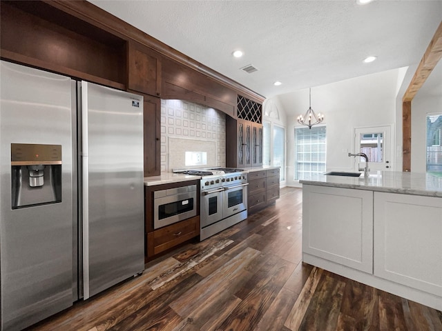 22014 Mission Hills Ln, Katy, TX 77450 - kitchen with appliances with stainless steel finishes, a sink, dark wood-type flooring, a chandelier, and light stone countertops