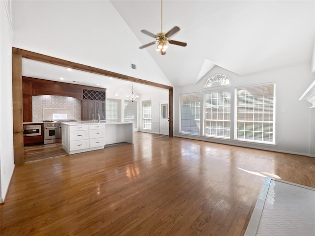 22014 Mission Hills Ln, Katy, TX 77450 - unfurnished living room with high vaulted ceiling, a chandelier, wood finished floors, ceiling fan, and baseboards