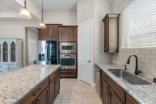 1810 Evergreen Bay Ln, Katy, TX 77494 - kitchen with stainless steel appliances, a sink, tasteful backsplash, decorative light fixtures, and light stone counters