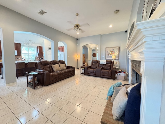 18003 Moss Park Ct, Humble, TX 77346 - living room featuring a ceiling fan, light tile patterned floors, a fireplace, recessed lighting, and arched walkways