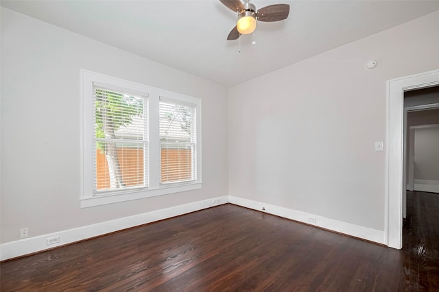 spare room with dark wood finished floors, baseboards, a ceiling fan, and a smoke detector