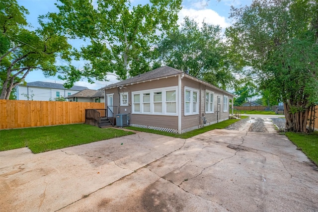 rear view of property with central AC and driveway