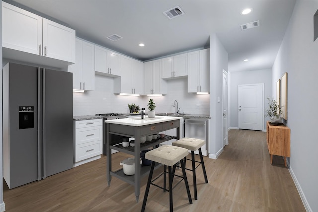 18830 Elegance Ave, Spring, TX 77379 - kitchen featuring appliances with stainless steel finishes, baseboards, backsplash, light wood-style floors, and recessed lighting