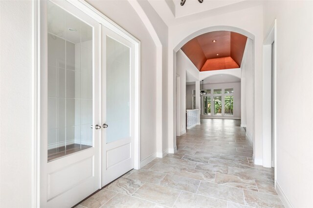 23335 Robinson Pond Dr, New Caney, TX 77357 - hall featuring arched walkways, baseboards, vaulted ceiling, and light stone finish flooring