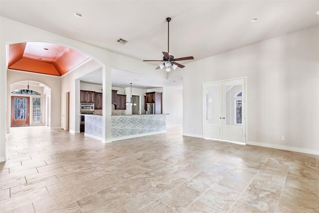 23335 Robinson Pond Dr, New Caney, TX 77357 - unfurnished living room with arched walkways, ceiling fan, baseboards, vaulted ceiling, and recessed lighting