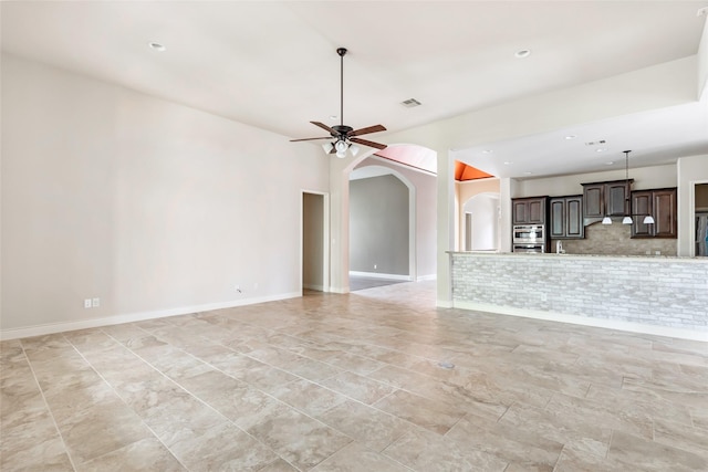 23335 Robinson Pond Dr, New Caney, TX 77357 - unfurnished living room featuring arched walkways, ceiling fan, recessed lighting, and baseboards