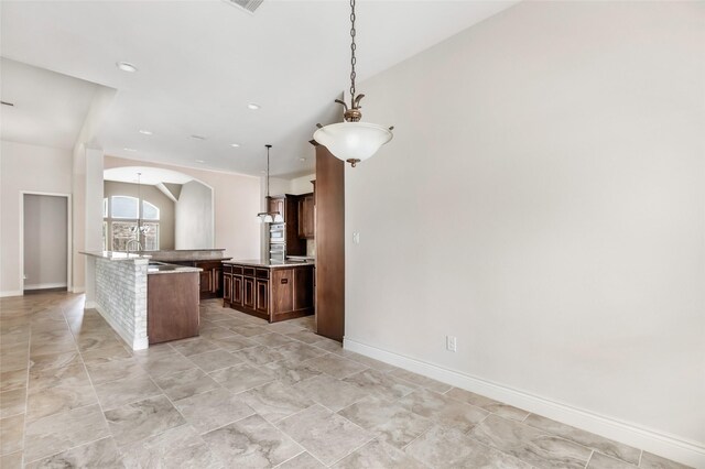 23335 Robinson Pond Dr, New Caney, TX 77357 - kitchen featuring arched walkways, light countertops, pendant lighting, baseboards, and recessed lighting