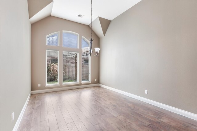 23335 Robinson Pond Dr, New Caney, TX 77357 - unfurnished room with a chandelier, plenty of natural light, wood finished floors, baseboards, and lofted ceiling