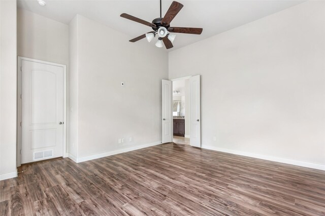 23335 Robinson Pond Dr, New Caney, TX 77357 - empty room with high vaulted ceiling, wood finished floors, a ceiling fan, and baseboards