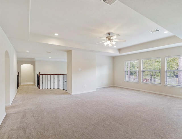14414 Spring Mountain Dr, Tomball, TX 77377 - spare room with a raised ceiling, arched walkways, a ceiling fan, light colored carpet, and recessed lighting